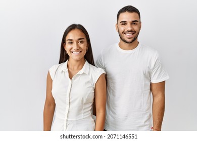Young interracial couple standing together in love over isolated background with a happy and cool smile on face. lucky person. 