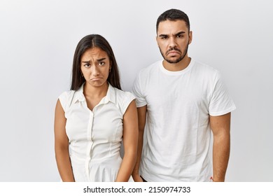Young Interracial Couple Standing Together In Love Over Isolated Background Depressed And Worry For Distress, Crying Angry And Afraid. Sad Expression. 