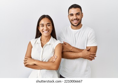 Young interracial couple standing together in love over isolated background happy face smiling with crossed arms looking at the camera. positive person. 