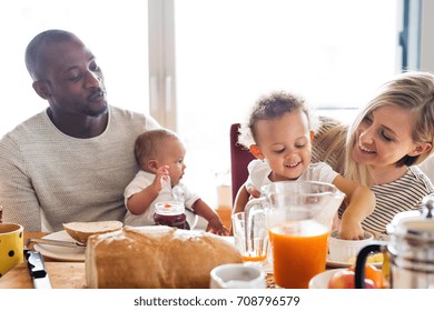 Young interracial family with little children having breakfast. - Shutterstock ID 708796579