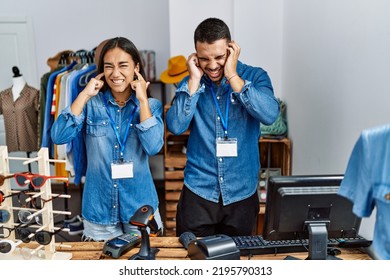 Young Interracial People Working At Retail Boutique Covering Ears With Fingers With Annoyed Expression For The Noise Of Loud Music. Deaf Concept. 