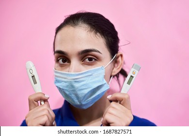 Young Iranian woman in medical mask. Portrait of middle eastern female with thermometers. Stay at home, have fun at quarantine during COVID19 pandemic