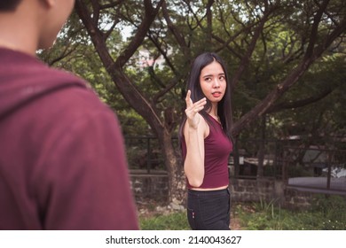 A young irate woman pointing in a condescending manner to a guy trying to catcall her. Standing her ground and being brave. Calling out and confronting a rude man. - Shutterstock ID 2140043627