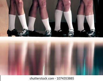 Young Irish Dance Girls Team in a Line on Stage in Hard Jig Shoes with Rainbow Colorful Reflection on Floor