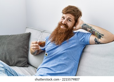 Young Irish Man Drinking Tea Sitting On The Sofa At Home.