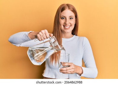 Young Irish Woman Pouring Water Smiling With A Happy And Cool Smile On Face. Showing Teeth. 