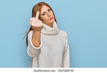 Young irish woman wearing casual winter sweater showing middle finger, impolite and rude fuck off expression 