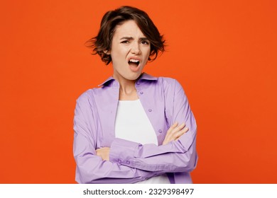 Young irritated indignant annoyed sad caucasian woman she wearing purple shirt white t-shirt casual clothes hold hands crossed isolated on plain orange background studio portrait. Lifestyle concept - Shutterstock ID 2329398497