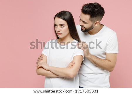 Young irritated offended sad couple two friends man woman in white basic t-shirts pout sulk sorry have problem stress need family psychologist isolated on pastel pink color background studio portrait