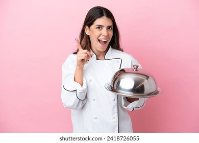 Young Italian chef woman holding tray with lid isolated on pink background intending to realizes the solution while lifting a finger up - Powered by Shutterstock