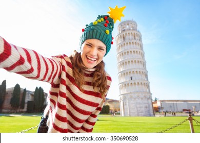 Young, itching from energy and searching for excitement. I'm going to Christmas trip to Italy. It is a no-brainer. Happy woman in Christmas tree hat taking selfie in front of Leaning Tour of Pisa