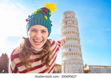 Young, itching from energy and searching for excitement. I'm going to Christmas trip to Italy. It is a no-brainer. Happy woman in Christmas tree hat pointing on Leaning Tour of Pisa