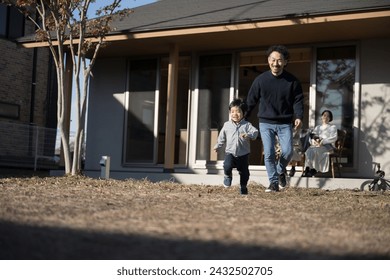 A young Japanese child running around the garden and his family watching over him. Father, mother, baby and grandmother. - Powered by Shutterstock