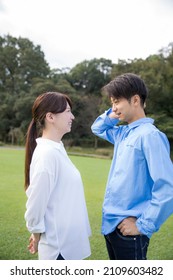 A Young Japanese Couple Staring At Each Other And Being Shy