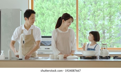 Young Japanese Family Cooking In The Kitchen