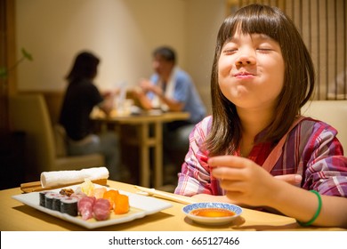 Young Japanese Girl eating Sushis in Hokkaido, Japan.