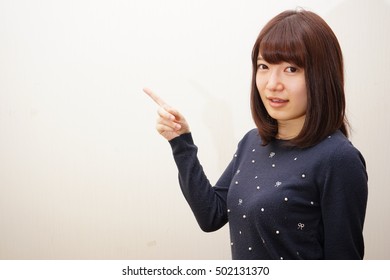 Young Japanese woman pointing something with smile