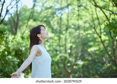 Young Japanese Woman Relaxing In The Woods