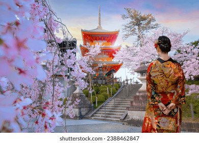 Young Japanese woman in a traditional Kimono dress stroll in Kiyomizu-dera Buddhist temple in Kyoto, Japan during full bloom cherry blossom in spring
