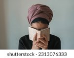 Young jewish woman with a covered head prays with a siddur (jewish prayer book) in her hands, covered his face with her hands (66)