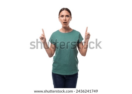 young joyful positive black-haired woman in a green basic t-shirt reports the news on a white background with copy space [[stock_photo]] © 