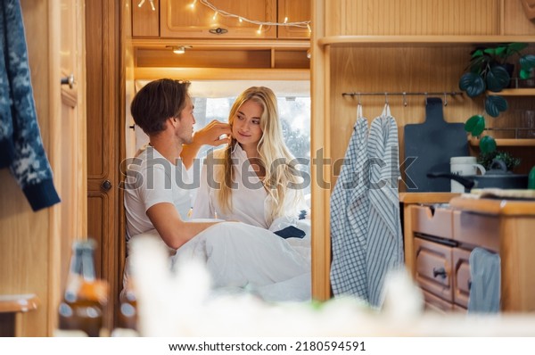 Young just married couple\
traveling in camper,house on wheels,trailer,motor home.Love\
romantic road travel,freedom life. Small bed,bedroom in\
van.Wanderlust vacation,weekend. Girl,guy,happy\
adventure.