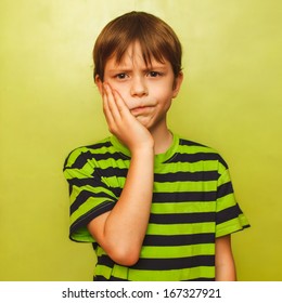 Young Kid Boy Child Toothache Pain In Mouth, Dental Pain, Holding His Cheek On A Green Background