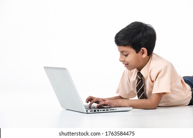 Young Kid Boy In School Dress Laying On Floor And Using Laptop