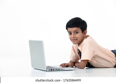 Young Kid Boy In School Dress Laying On Floor And Using Laptop