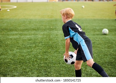 Young Kid Boy Training With Soccer Ball Alone In Stadium, Practice Various Tricks, Before Game