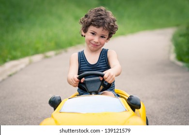 Young Kid Close Up Portrait With Toy Car Outdoors.