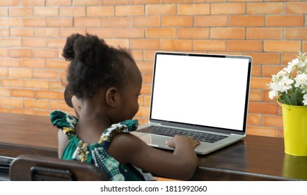 Young Kid Girl, Black African Baby Student Woman Person Learning, Studying Homework Online, Using A Computer Notebook Laptop And Blank Empty Screen Space At Home In Education Concept.