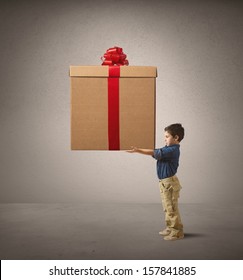 Young Kid Holding A Big Christmas Present