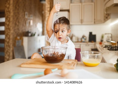 Young Kid Mixing Melted Chocolate In A Bowl