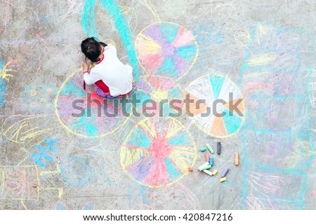 Young kid playing with chalk.