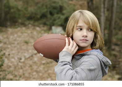 Young Kid Practicing Throwing A Football Outside