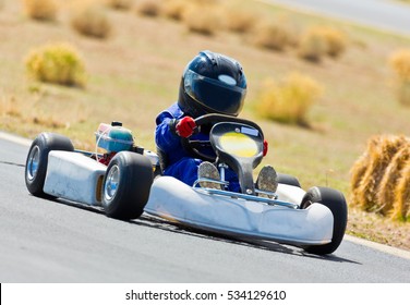 Young Kid Racing A Go Cart Around A Track