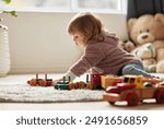 Young kid, toys and play in bedroom for development or learning, child in home for motor skills. Baby, house and relax game with wood cars for education or creativity, wellness or cognitive growth