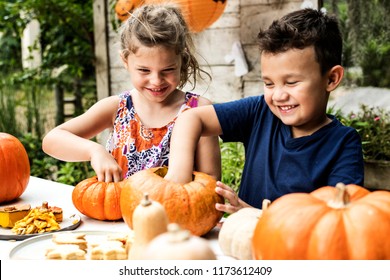Young kids carving Halloween jack-o-lanterns - Shutterstock ID 1173612409