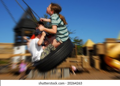 Young Kids Having Fun On Tire Swing