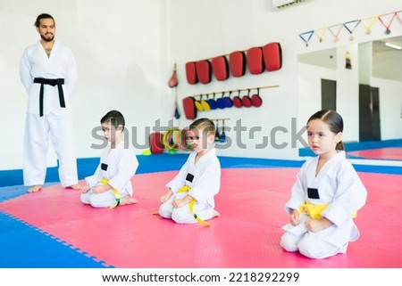 Young kids preparing to start their karate or taekwondo class at the martial arts school