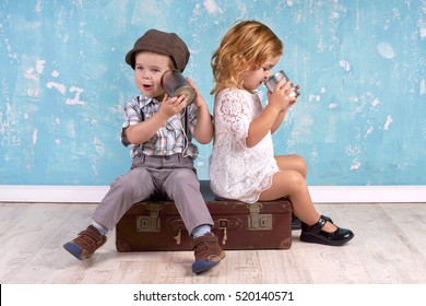 Young kids talking with tin can telephone on grunge background.                                