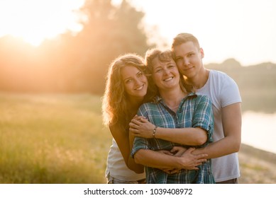 Young kids with their loving mother on nature background