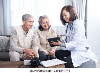 young kind asian female doctor in uniform visiting a senior patient at home,evaluate,collect data and provide advice patient care on tablet,concept of aging care,home care,home health care - Powered by Shutterstock