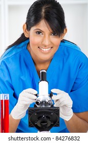 Young Lab Technician Using Microscope