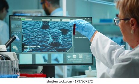 Young Laboratory Scientist Working With Blood Test Late At Night In Modern Equipped Lab. Team Examining Virus Evolution Using High Tech For Scientific Research Of Treatment Development Against Covid19