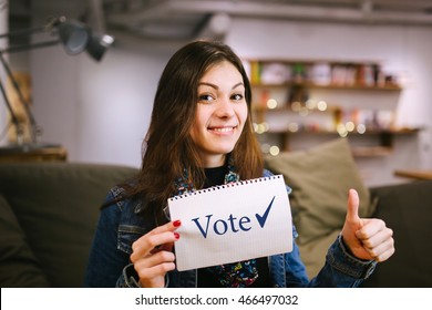 Young Lady Is Agitating To Vote In Elections. Women Brunette Enjoys Voting.
Beautiful Woman Holding A Sheet Of Paper With The 