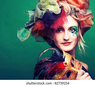 Young lady in carnival costume with mask in her hands