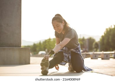 Young Lady Doing Pre-workout Activities On A City Roadside - Stock Photo