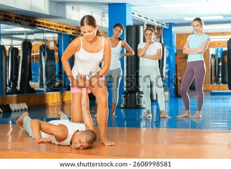 Young lady doing wristlock movement during self defense training.